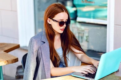 girl working on laptop in coffee shop